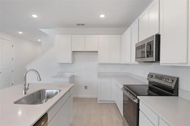 a kitchen that has a sink and a stove top oven