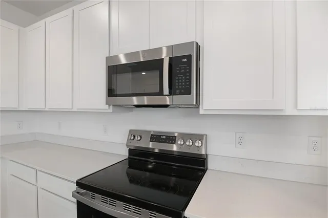 a kitchen with stainless steel appliances a stove and cabinets