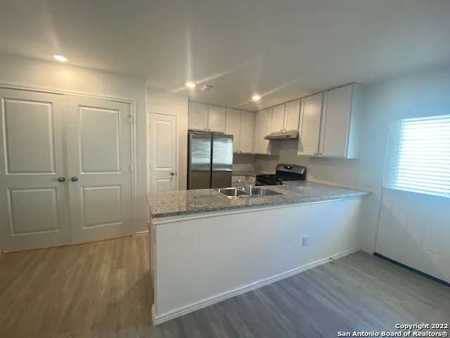 a kitchen with stainless steel appliances granite countertop a sink and cabinets