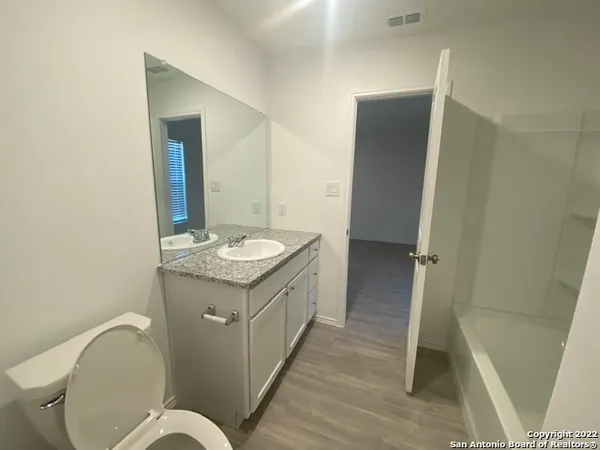a spacious bathroom with a granite countertop sink toilet and shower
