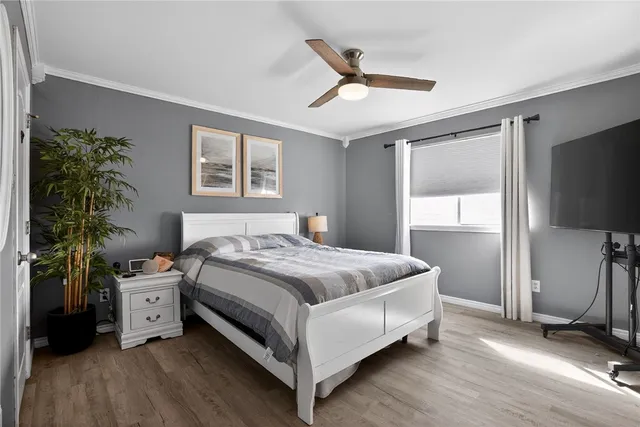 a bedroom with a bed and a flat tv screen on dresser