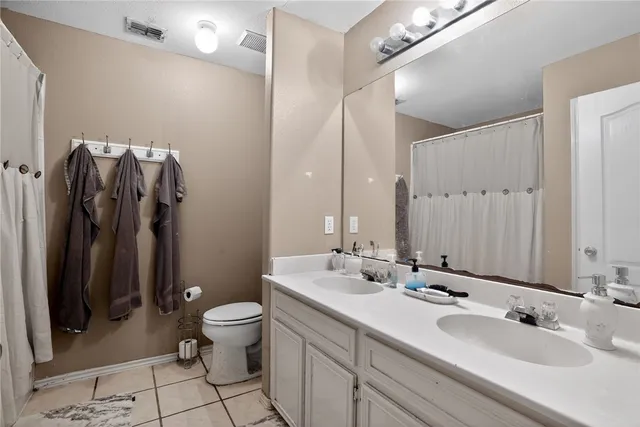 a bathroom with a double vanity sink mirror and toilet