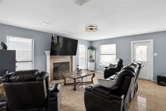 a living room with furniture a flat screen tv and a fireplace
