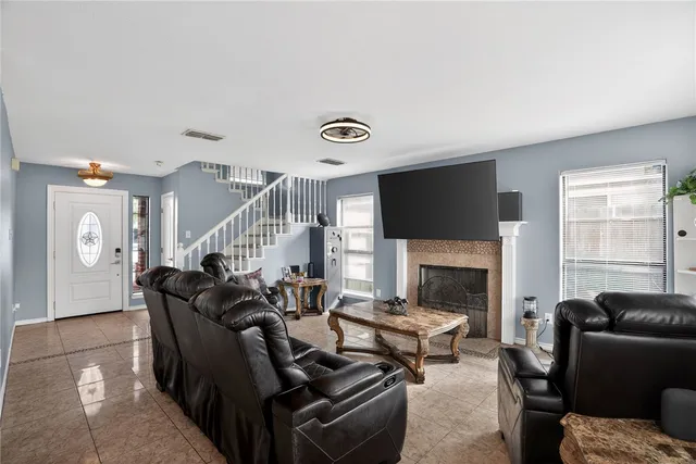 a living room with furniture fireplace and a window