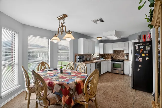 a dining room with stainless steel appliances a kitchen island a stove a table and chairs