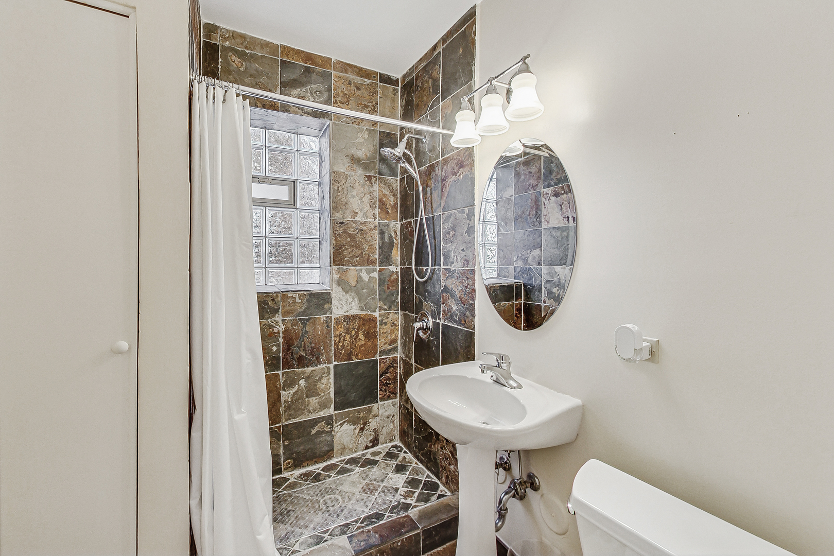 138 Custer Avenue, Unit 2 Evanston, IL 60202 - Photo 19 of 22 a bathroom with a sink a toilet and shower