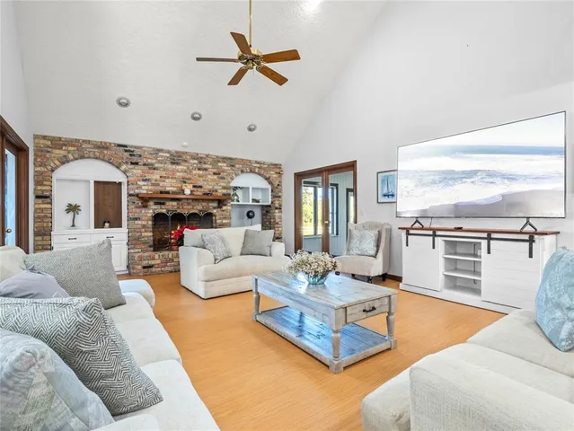 a spacious bedroom with a bed chandelier and a large window