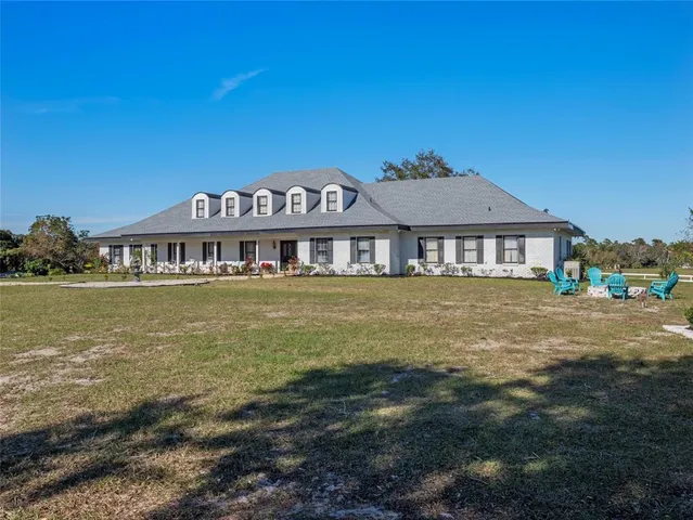 a view of a big house with a big yard and potted plants