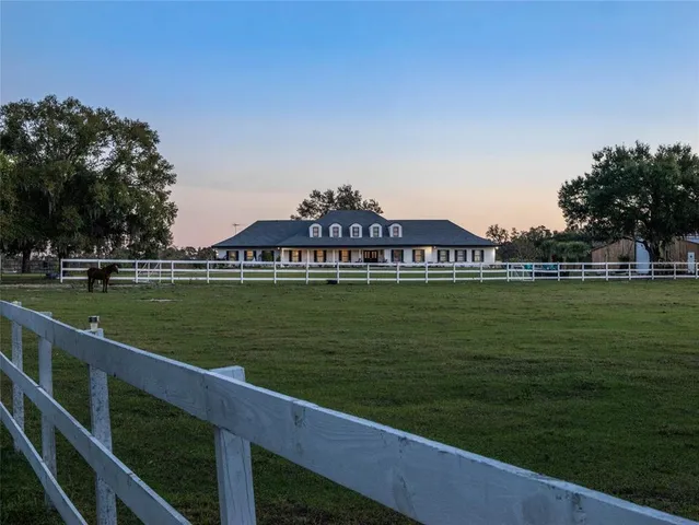 a dining room with furniture a chandelier and wooden floor