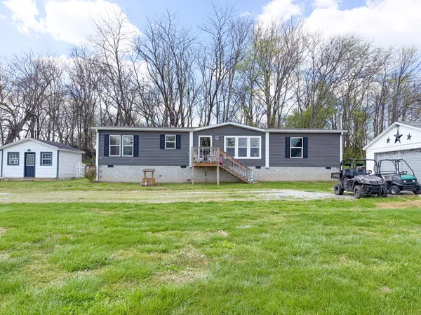 a view of a house with a yard and sitting area