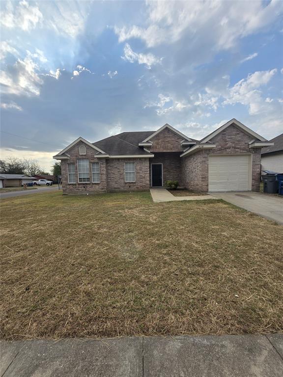 a view of a house with a yard and a large tree