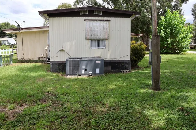 a view of backyard with barbeque grill and a large tree