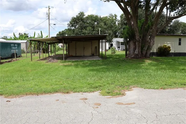 a view of a chair and table in backyard of the house