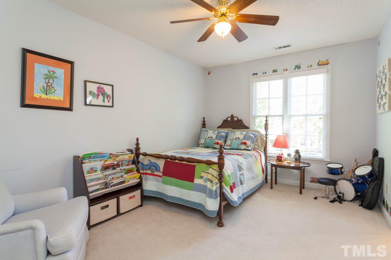12308 Hartwick Court Raleigh, NC 27613 - Photo 17 of 20 a bedroom with a bed and a chandelier