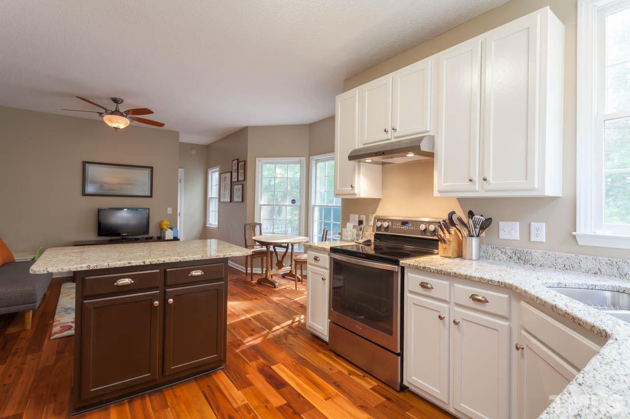 12308 Hartwick Court Raleigh, NC 27613 - Photo 7 of 20 a kitchen with stainless steel appliances granite countertop a stove a sink and a microwave