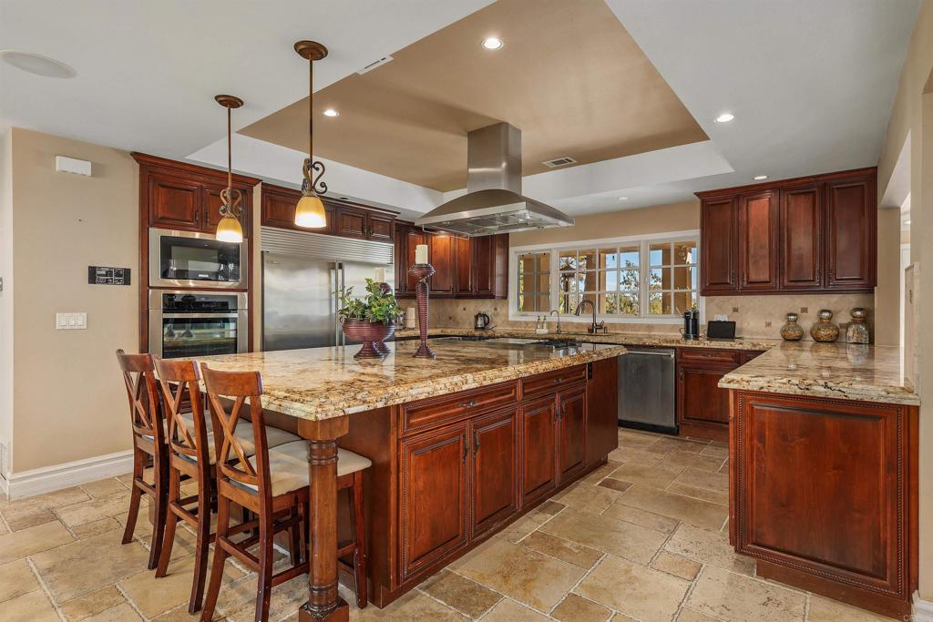 16346 Via Del Alba Rancho Santa Fe, CA 92067 - Photo 7 of 34 a kitchen with stainless steel appliances granite countertop a stove a sink a refrigerator and chairs