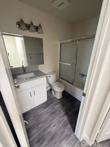 a bathroom with a granite countertop sink toilet and mirror