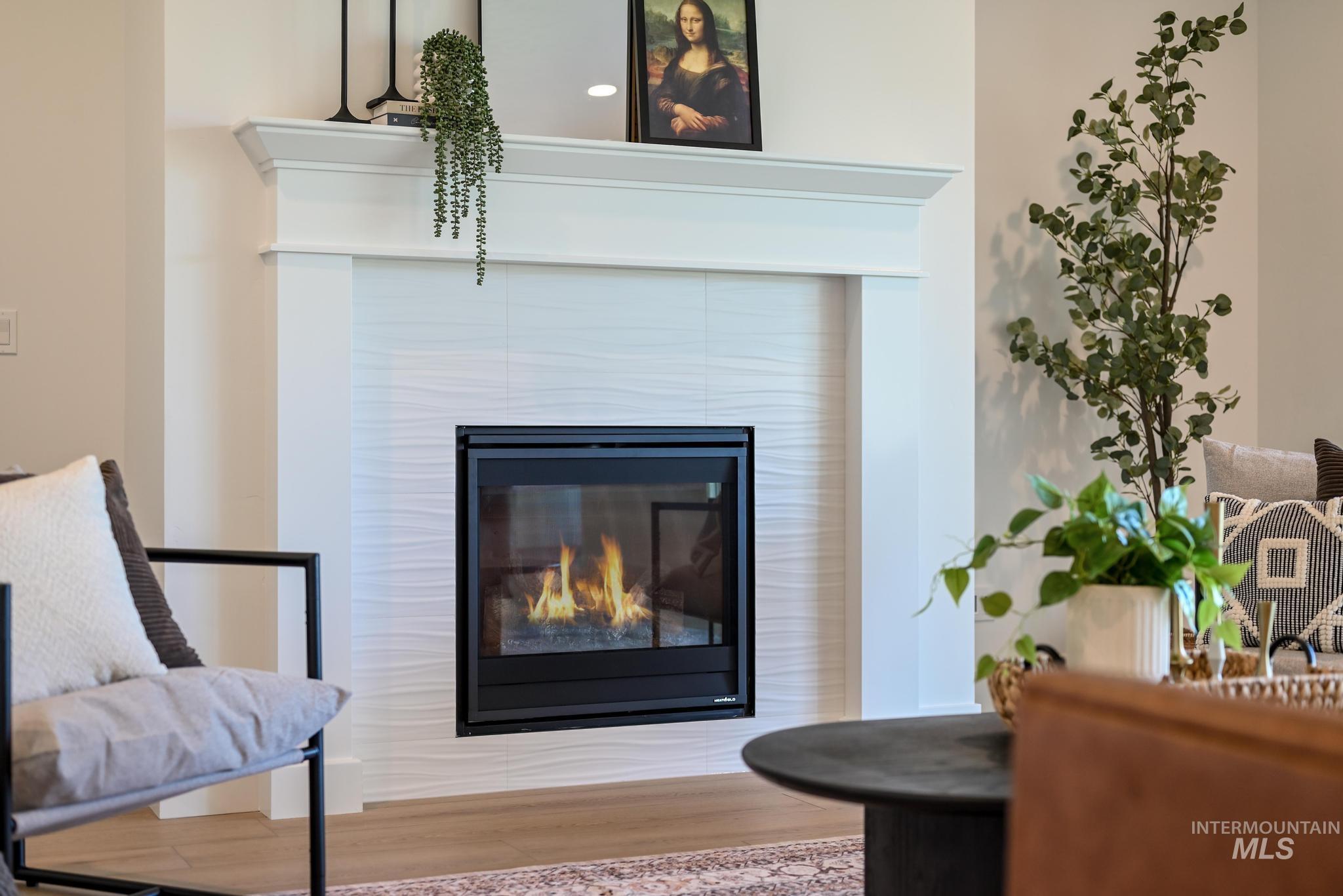 9074 West Moonglade Street Star, ID 83669 - Photo 7 of 40 Contemporary fireplace with textured tile surround, classic white mantel, and black-framed insert