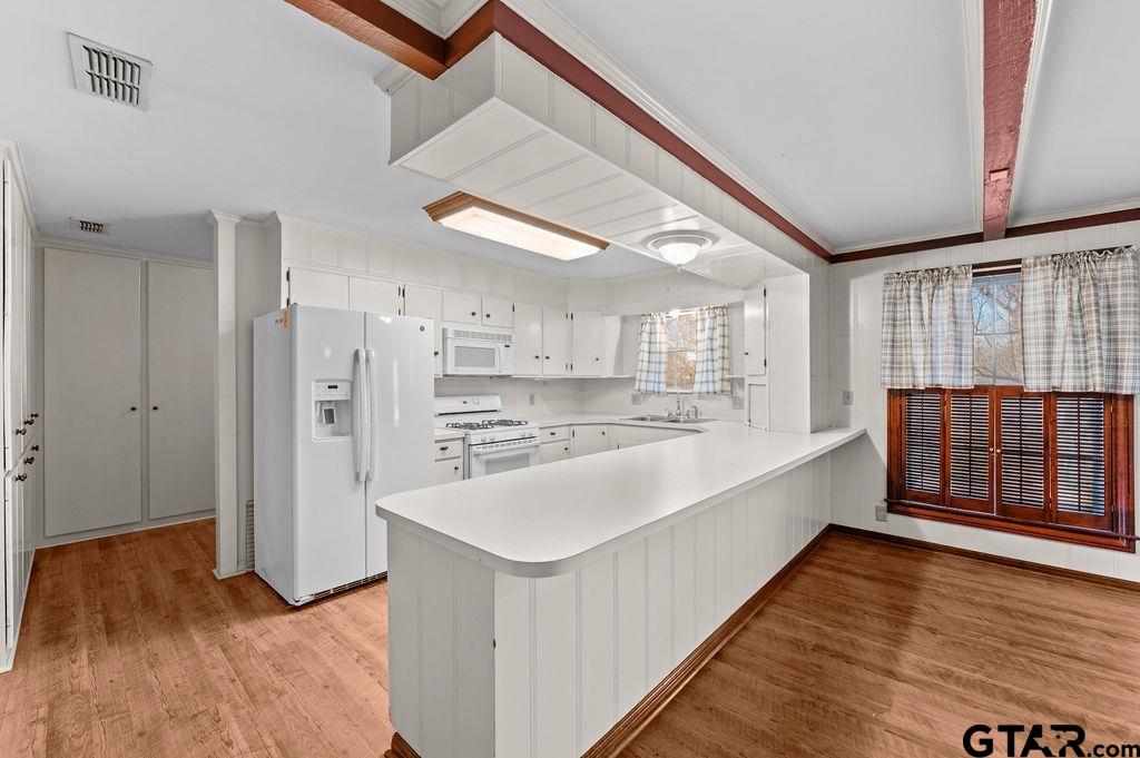 610 Tamy Street Quitman, TX 75783 - Photo 8 of 29 a large white kitchen with wooden floor and large windows