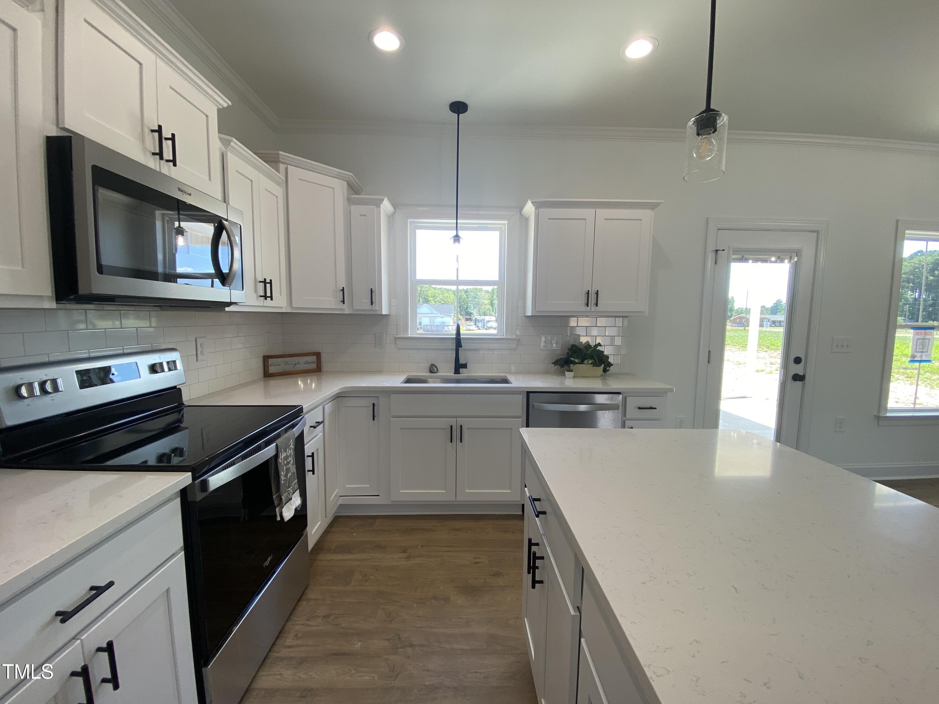 137 Ralph Drive Pikeville, NC 27863 - Photo 8 of 19 a kitchen with stainless steel appliances a stove sink microwave and cabinets