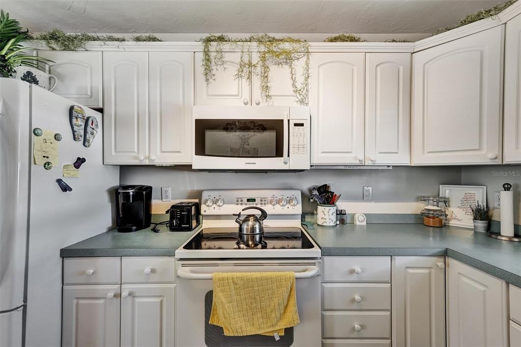 10315 Cortez Road West, Unit 19H Bradenton, FL 34210 - Photo 13 of 47 a kitchen with stainless steel appliances granite countertop a refrigerator a stove a microwave and cabinets