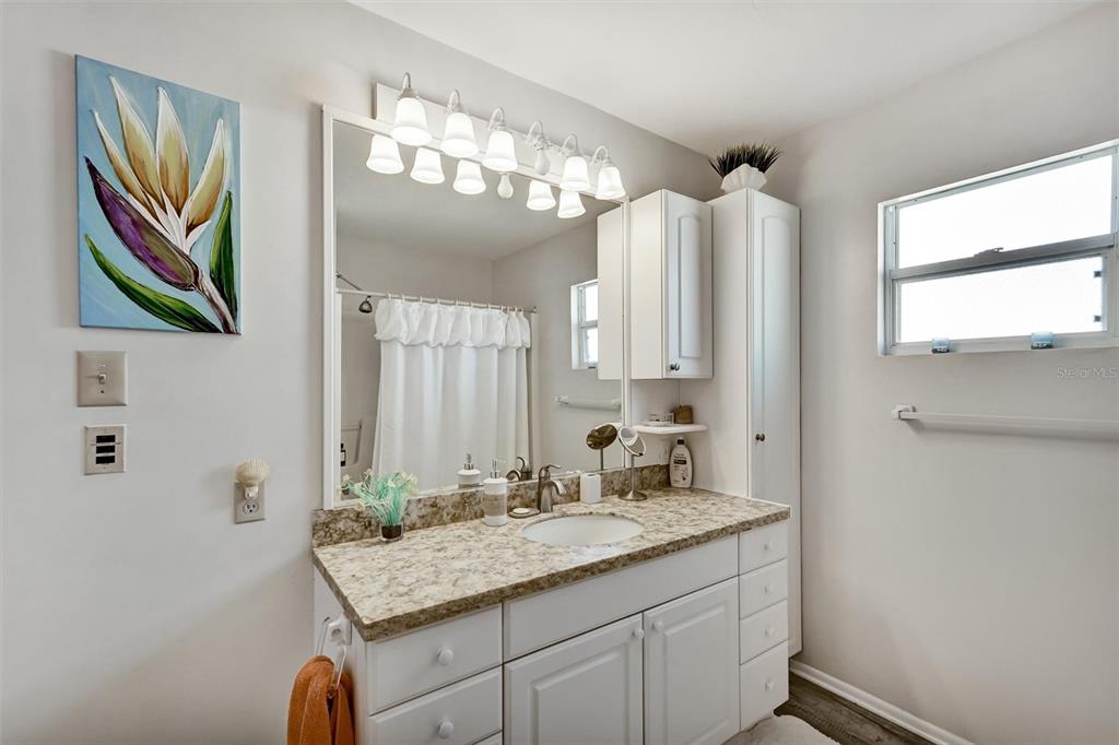 10315 Cortez Road West, Unit 19H Bradenton, FL 34210 - Photo 25 of 47 a bathroom with a granite countertop sink a large mirror and a shower