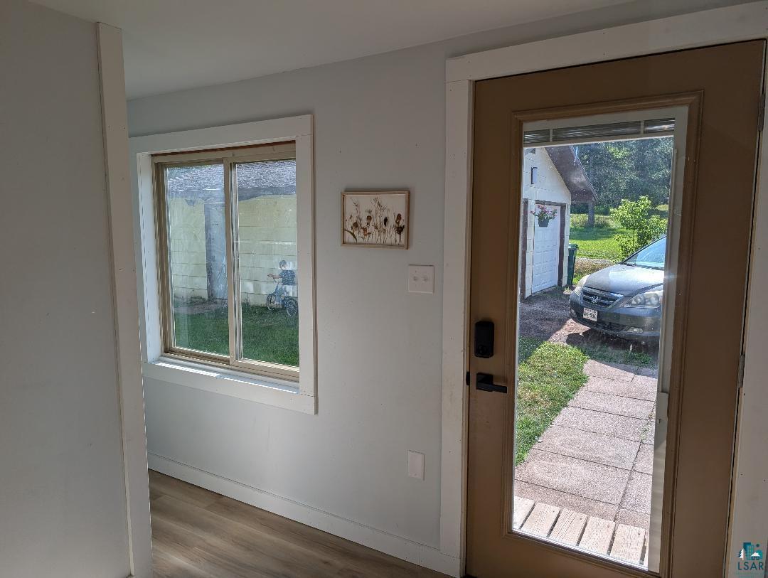 701 Drake Street Mellen, WI 54546 - Photo 13 of 27 Entryway featuring a full-light panel door with a smart lock, wood-finish flooring, and white trim