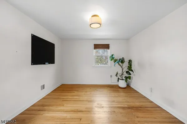 a view of a room with wooden floor and a window