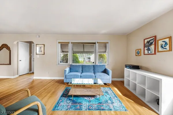 a view of a room with a table chairs and wooden floor
