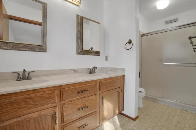 a bathroom with a granite countertop sink toilet and shower
