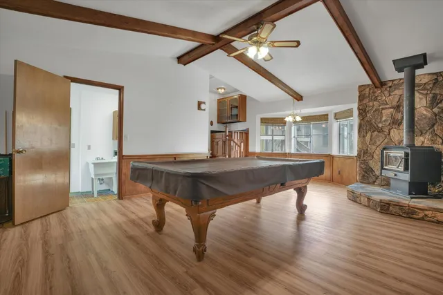 a living room with table chairs and wooden floors