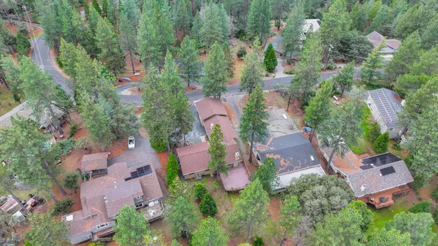 an aerial view of residential house with outdoor space and trees all around