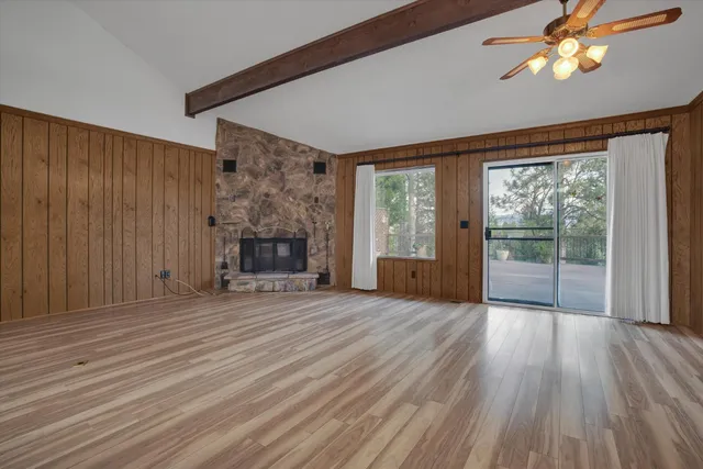 wooden floor fireplace and windows in an empty room