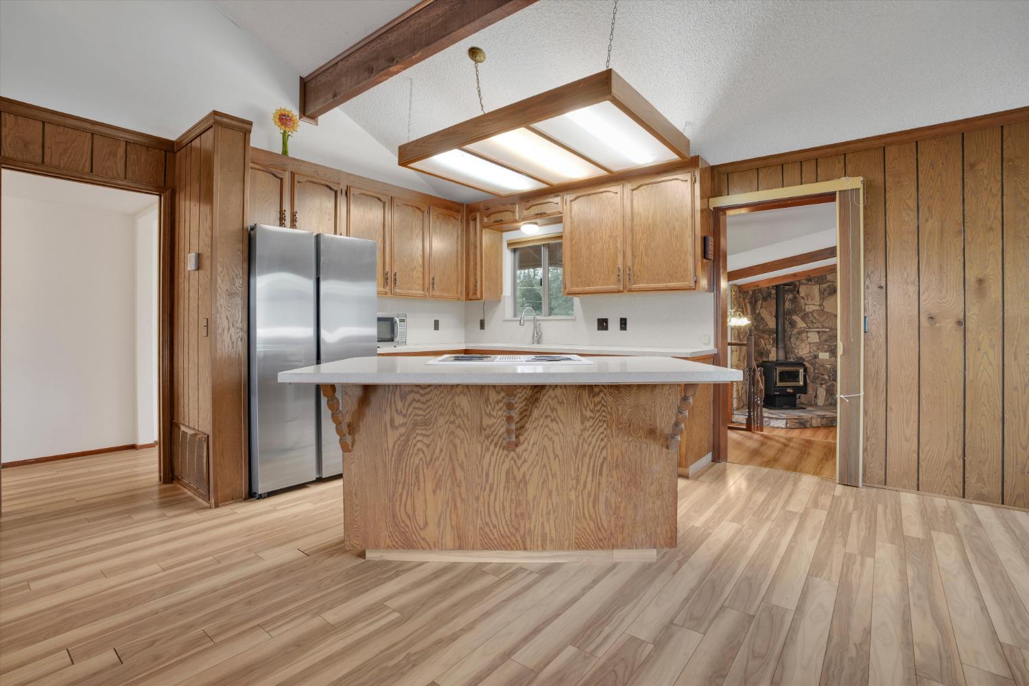 12066 Breckenridge Road Groveland, CA 95321 - Photo 9 of 41 a kitchen with kitchen island a counter top space a sink and a refrigerator