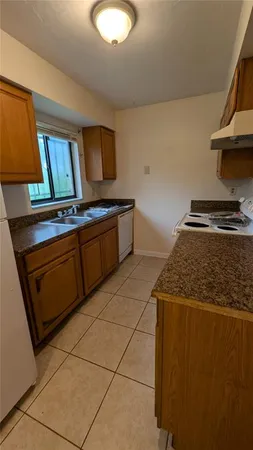 a kitchen with granite countertop a stove and a sink