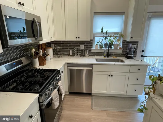 a kitchen with a sink appliances and cabinets