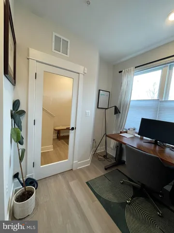 a view of a workspace with furniture and a window