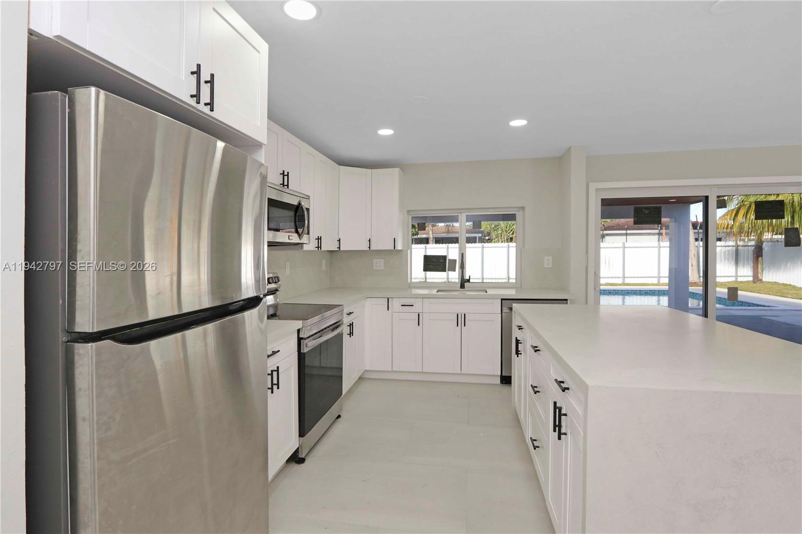 16232 Southwest 107th Court Miami, FL 33157 - Photo 8 of 32 a kitchen with white cabinets and stainless steel appliances