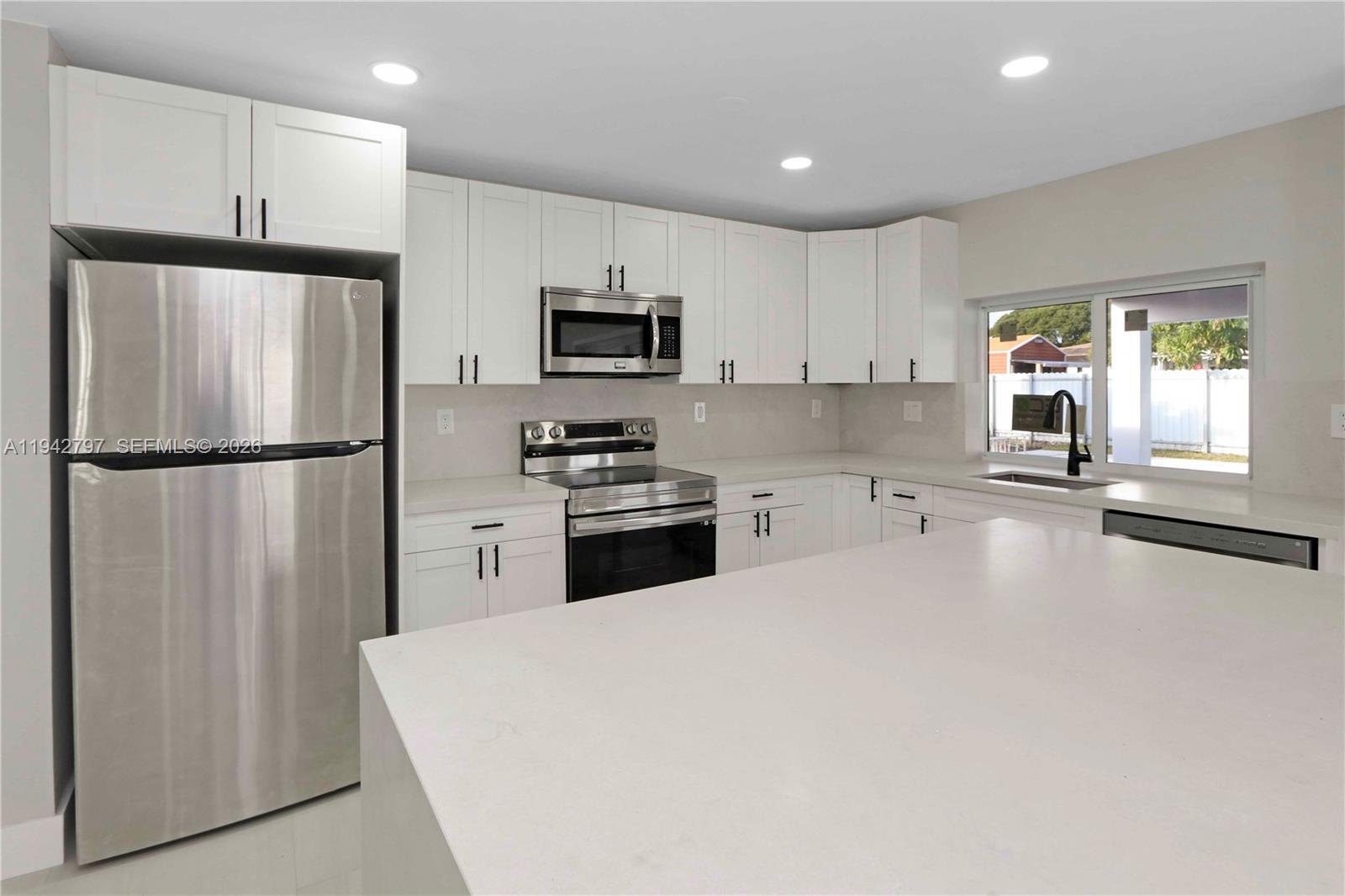 16232 Southwest 107th Court Miami, FL 33157 - Photo 9 of 32 a kitchen with stainless steel appliances a refrigerator stove microwave and sink