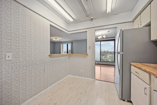 a view of a hallway with wooden floor and cabinet