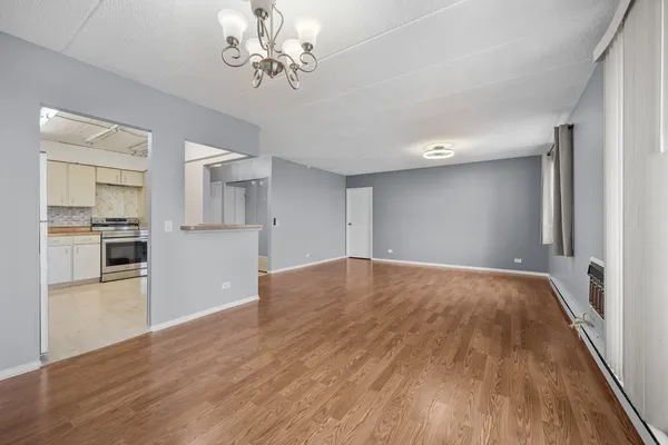 a view of a kitchen with wooden floor and a kitchen space