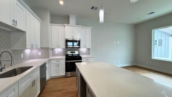 a kitchen with stainless steel appliances a sink stove and cabinets