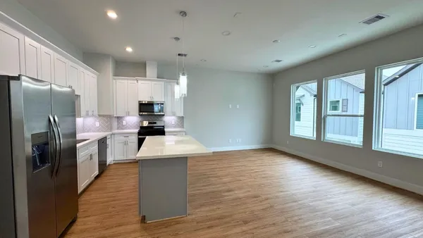 a kitchen with stainless steel appliances a refrigerator sink and stove