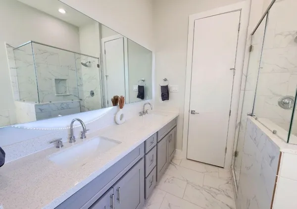 a bathroom with a double vanity sink a mirror and shower