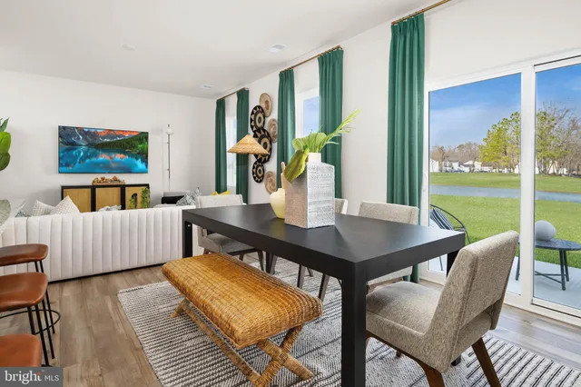 a view of a dining room with furniture a rug and wooden floor