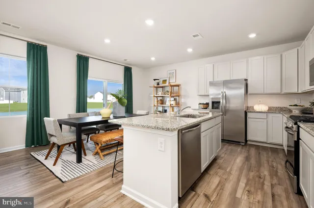 a kitchen with a sink a counter top space stainless steel appliances and a window
