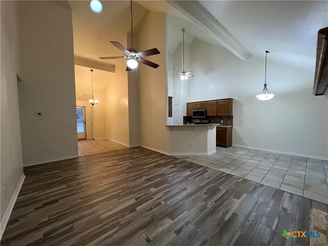 wooden floor in an empty room with a kitchen