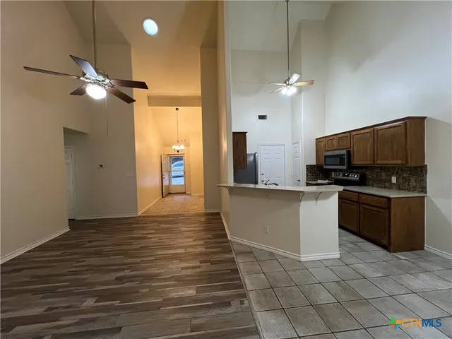a kitchen with a sink and a stove top oven with wooden floor