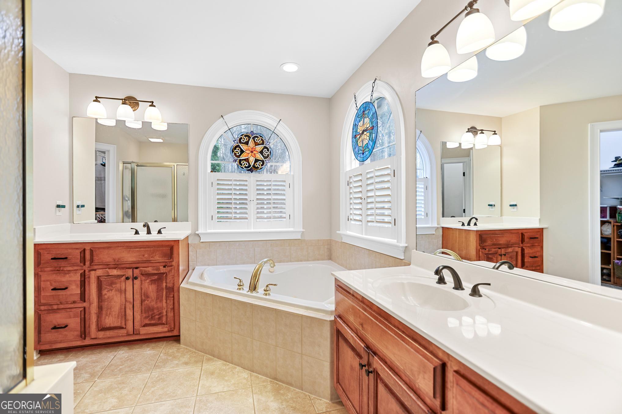 643 Old Greenville Road Fayetteville, GA 30215 - Photo 17 of 59 a spacious bathroom with a granite countertop double vanity sink a mirror and a bathtub