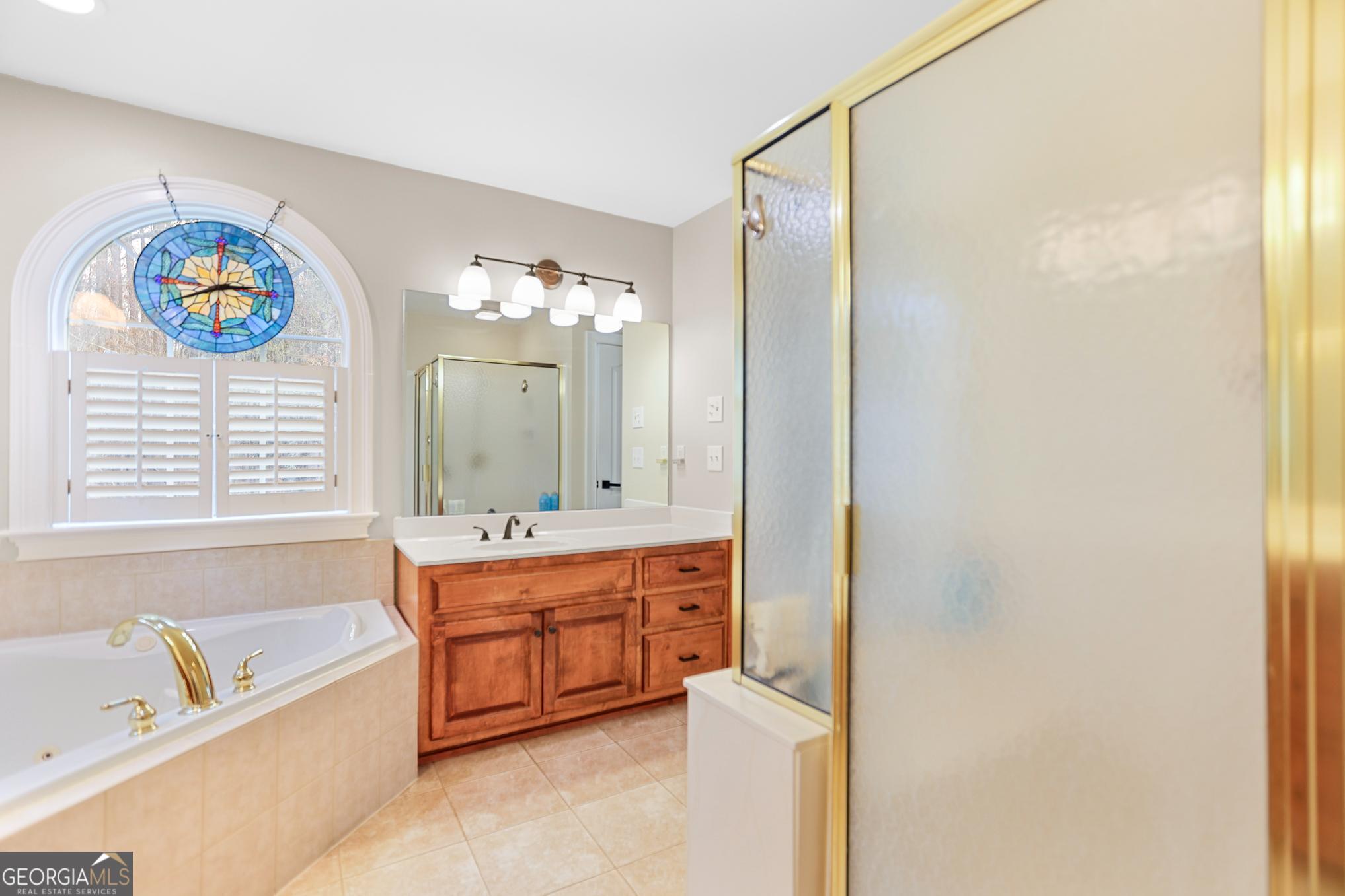 643 Old Greenville Road Fayetteville, GA 30215 - Photo 19 of 59 a bathroom with a tub a sink and a large mirror